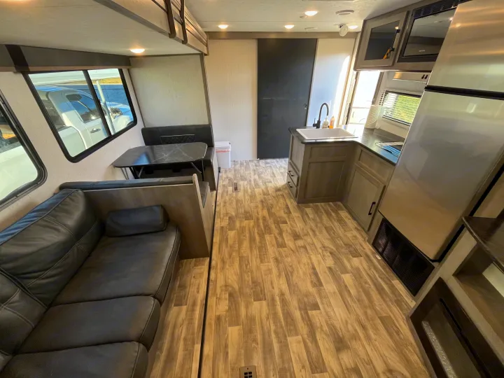 Spacious rv rental interior: living area with couch, dining dinette, and modern kitchen with appliances.. Dutchmen Kodiak Bunk House 2019