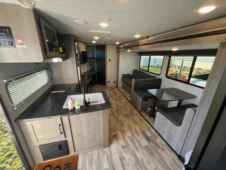 Clean, modern rv rental interior featuring a kitchen, dinette, and living area, ideal for comfortable travel.. Dutchmen Kodiak Bunk House 2019