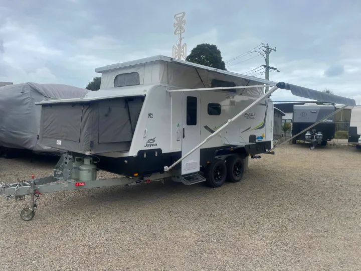 White Jayco pop-top caravan with top antenna & extended awning on gravel lot. An excellent RV rental choice for adventures.. Jayco 17.56-2.OB.MY18 2018