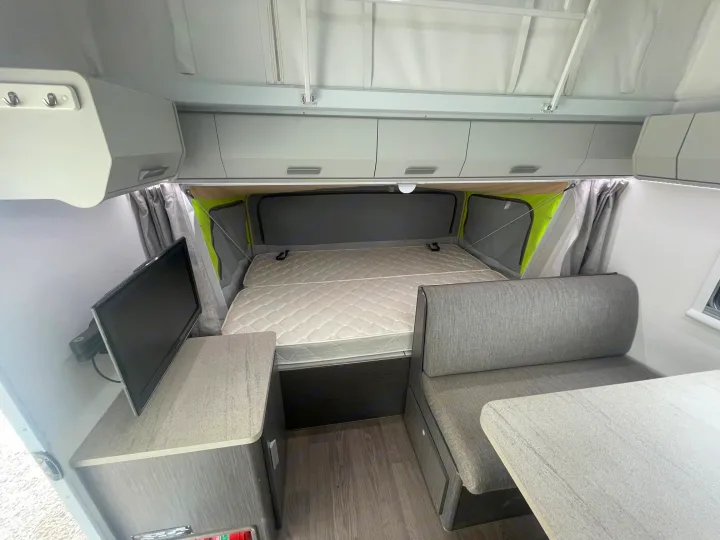 RV rental interior features a pop-top roof, comfy bed, dinette, and TV setup for your travels.. Jayco 17.56-2.OB.MY18 2018