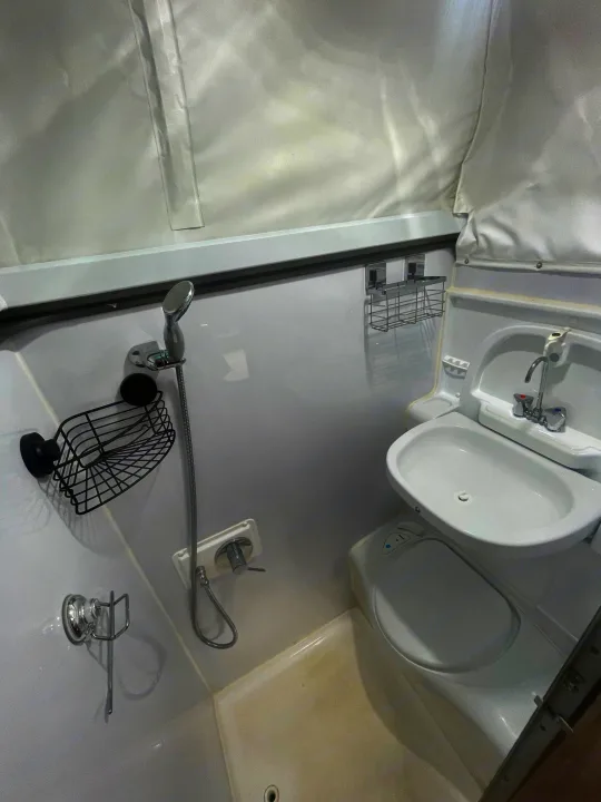 Compact RV rental wet bath featuring a shower, sink, and toilet in a white, efficient design.. Jayco 17.56-2.OB.MY18 2018