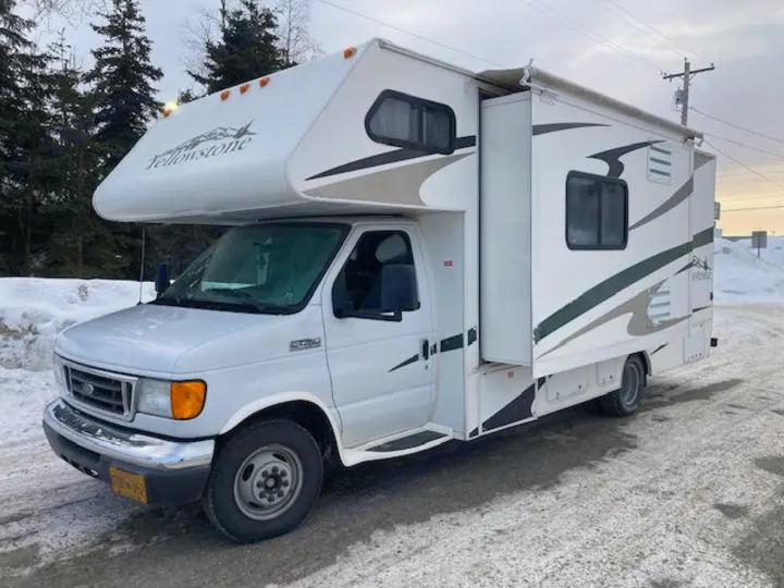 White Ford Class C Yellowstone RV rental on snowy road. Features extended slide-out. Great motorhome for your adventures.. Yellowstone Conquest M6254 2008