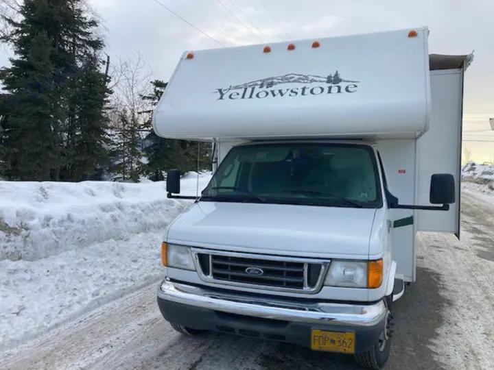 A white Yellowstone RV rental is parked on a snow-covered road in Alaska during winter.. Yellowstone Conquest M6254 2008