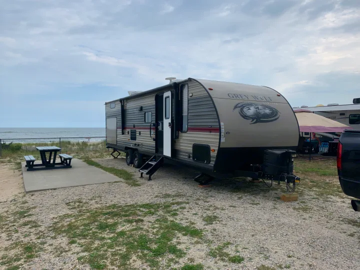 RV rental: Grey Wolf travel trailer parked at an oceanfront beach campsite with a picnic table.. Forest River Cherokee Grey Wolf 2019