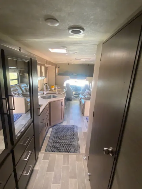 Spacious RV rental: interior view showing a full kitchen, comfy living area, and driver's cab.. Thor Chateau 2021