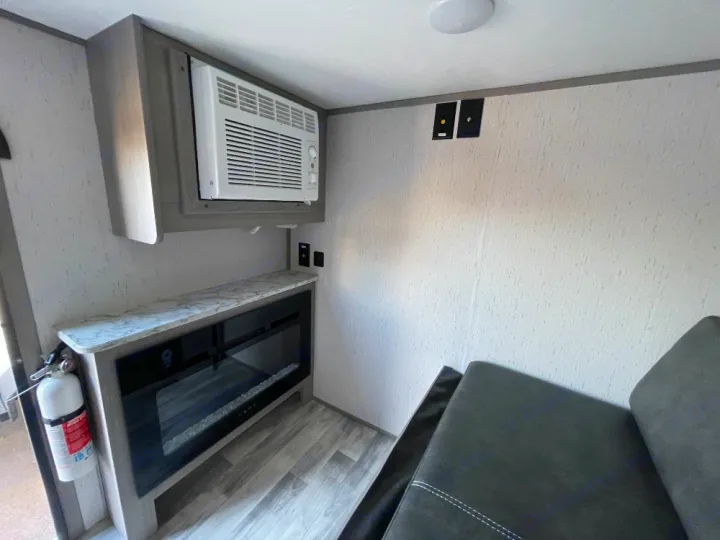 RV rental interior: Built-in AC, electric fireplace, and sofa ensure comfort for your travels.. Dutchmen Coleman Rubicon 2023