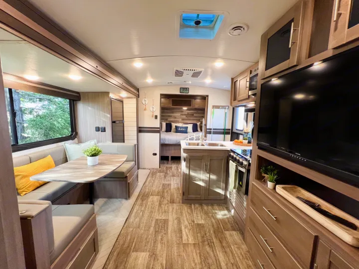 Bright and stylish rv rental interior featuring a dinette, well-equipped kitchen, and comfortable rear bedroom.. Crossroads RV Sunset Trail Super Lite 2022