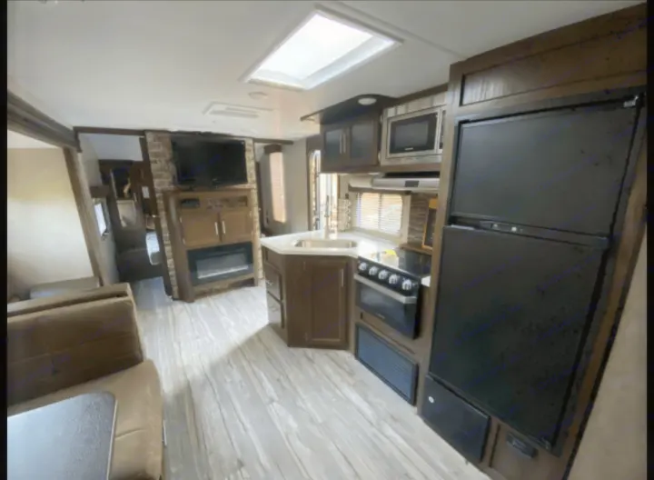 Explore this spacious RV rental interior featuring a modern kitchen, cozy living area, and ample amenities for your travels.. Forest River Cherokee Grey Wolf 2019
