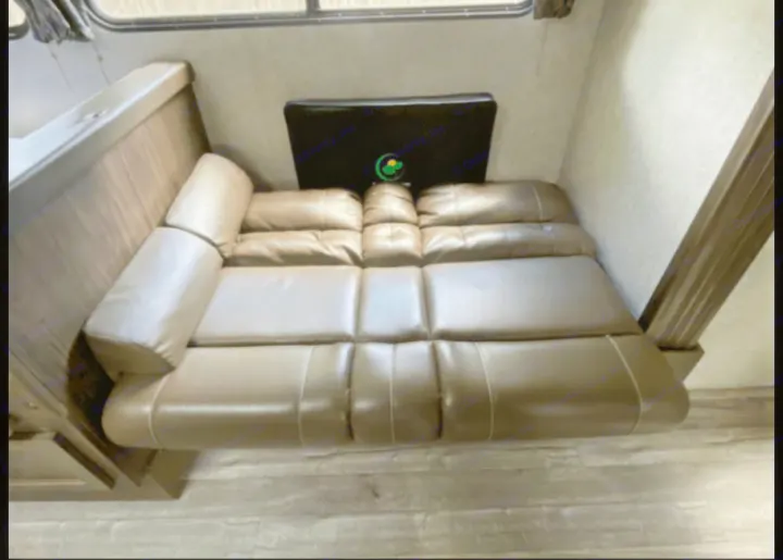 An RV rental's versatile brown jackknife sofa, set against light walls and wood-look flooring, provides adaptable seating.. Forest River Cherokee Grey Wolf 2019
