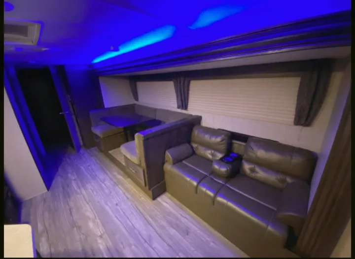 Spacious RV rental interior: modern lounge, dinette, and bright blue LED lighting create a cozy travel experience.. Forest River Cherokee Grey Wolf 2019