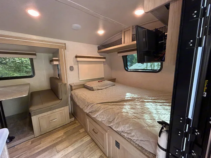 RV rental interior: bedroom with mounted TV, small dinette, and bright modern decor.. Geo pro Geo pro by rockwood 2022