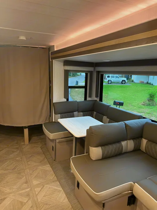 Spacious and modern RV rental interior with comfortable U-shaped dinette, perfect for relaxing and dining on your trip.. Forest River Salem FSX Platinum 2023