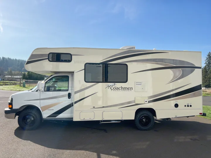 White Coachmen Freelander Class C RV rental, parked on asphalt with a clear sky.. Forest River Coachmen Freelander 2017
