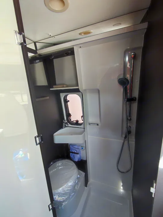 Compact rv rental bathroom featuring a full shower, small sink, and toilet. Efficient design for comfortable travels.. McLouis Menfys Van 3 Maxi 2024