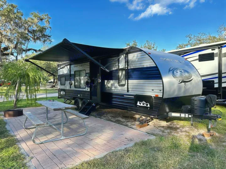 Experience camping with this RV rental parked at a serene site, complete with an awning, picnic table & fire pit.. Forest River Cherokee Grey Wolf 2022