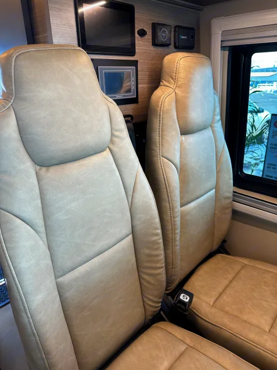 Modern RV rental interior: two plush seats, window view, and smart control panels for comfortable travel.. Mercedes-Benz Entegra Launch 2024
