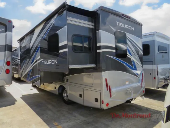 Modern grey and silver RV rental with blue accents and an extended slide-out, perfect for travel or camping adventures.. Thor Tiburon 2023