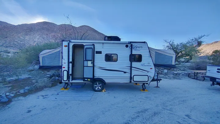 An rv rental travel trailer parked at a desert campsite, with mountains, a pop-up camper, and early morning sun.. Clipper Clipper Trailer 2016