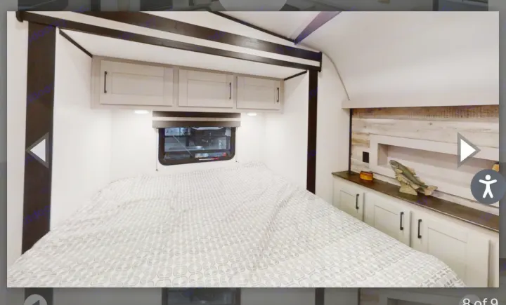 This RV rental bedroom offers a comfortable bed, overhead cabinets, and built-in storage. Ideal for camping and travel.. Heartland Torque 2022