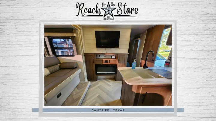 Modern RV rental interior: cozy living space, entertainment center with TV/fireplace, and full kitchen.. Forest River Salem Cruise Lite 2021