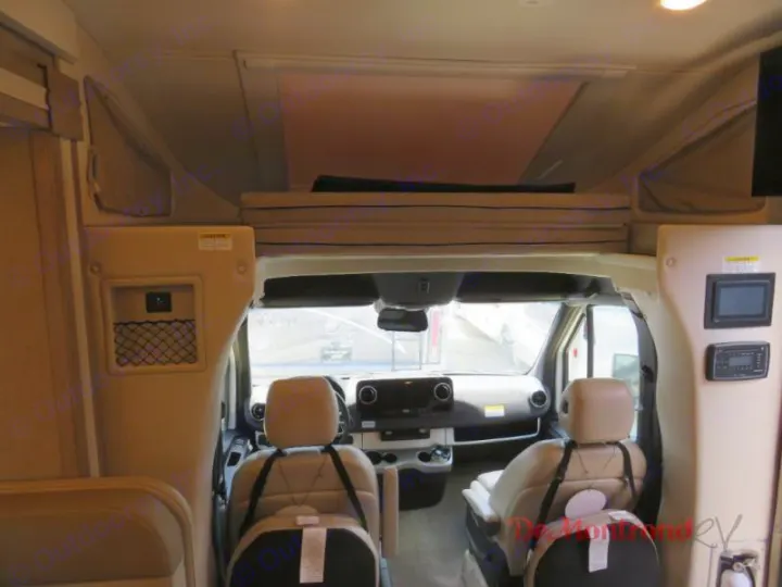 Interior of an RV rental: driver's cockpit, overhead bunk, and control panels are visible, ready for travel.. Thor Tiburon 2023