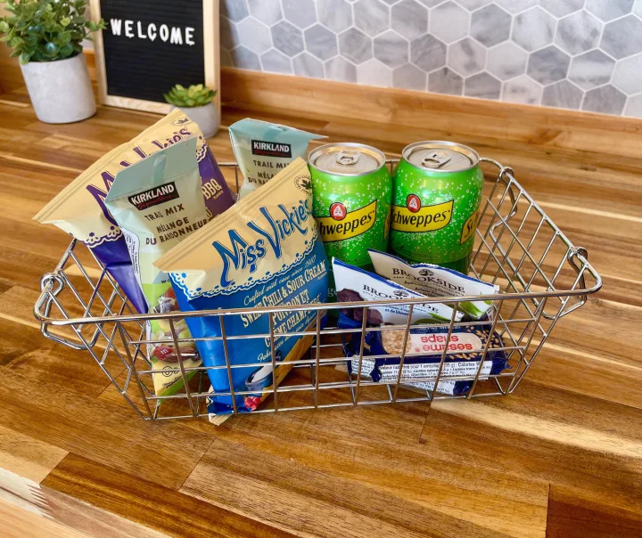 A thoughtful RV rental welcome basket: snacks including Miss Vickie's chips, trail mix, and Schweppes drinks, on a wooden counter.. Ford Ford E350 2011