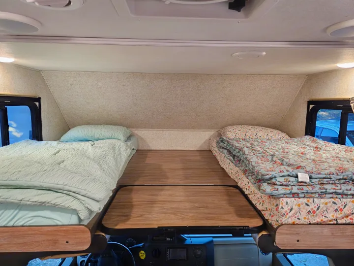 Two comfy beds in the overhead bunk of an RV rental, a cozy sleeping space above the cab.. Forest River Sunseeker 2019