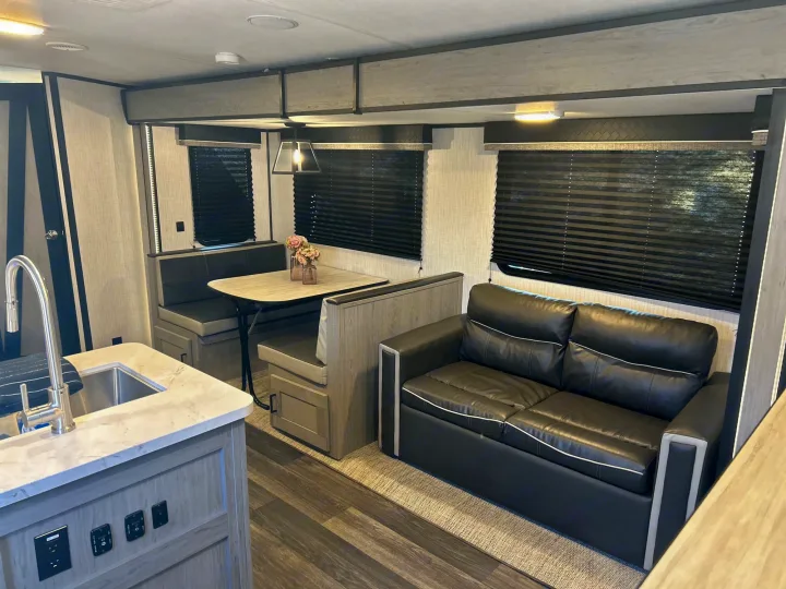 This inviting rv rental boasts a modern kitchen area, cozy dinette, and comfortable dark sofa. Your next road trip awaits!. Heartland RVs Mallard 2021