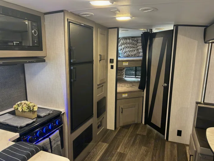 Explore this modern RV rental interior featuring a full kitchen, large fridge, and comfy bunk beds. Great for camper adventures!. Heartland RVs Mallard 2021