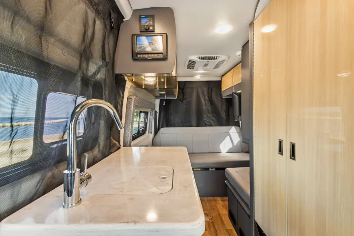Spacious RV rental interior featuring a modern kitchenette, comfortable seating, and smart controls, ideal for travel.. Thor Sanctuary 2023