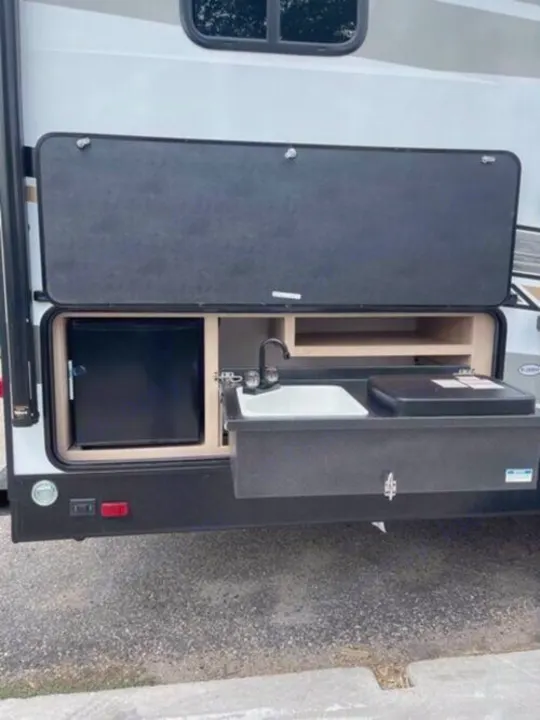 This RV rental features a convenient pull-out outdoor kitchen, complete with a fridge, sink, and cooktop, perfect for camping.. Cruiser Rv Corp Radiance 2022