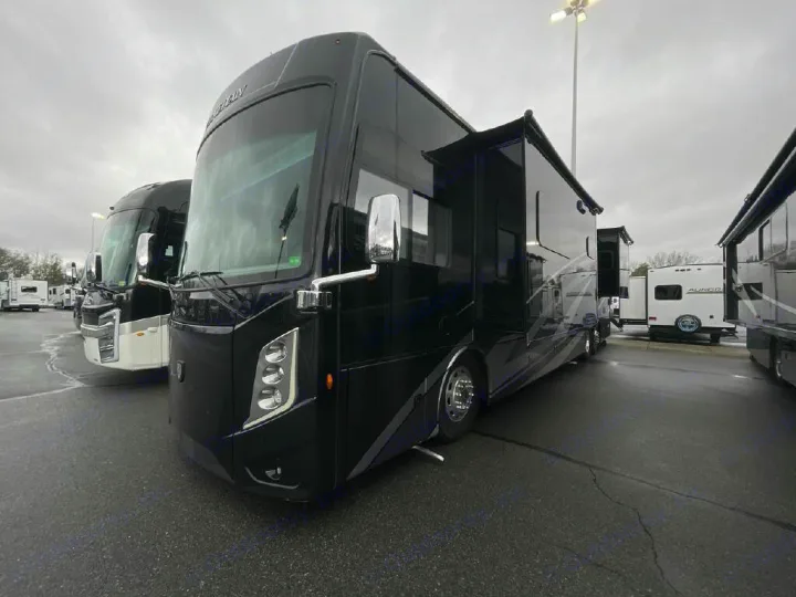 Black motorhome at an RV rental lot, ready for your next adventure. Slide-outs extended on this large RV.. Thor Motor Coach Venetian 2024