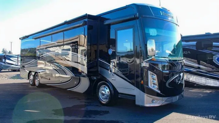 A large, black and silver luxury Venetian RV is parked outdoors.. Thor Motor Coach Venetian 2024