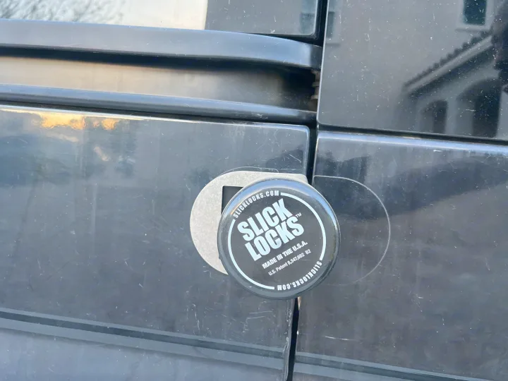A black Slick Locks disc lock secures an RV rental door, enhancing vehicle security.. Mercedes-Benz Sprinter 2016