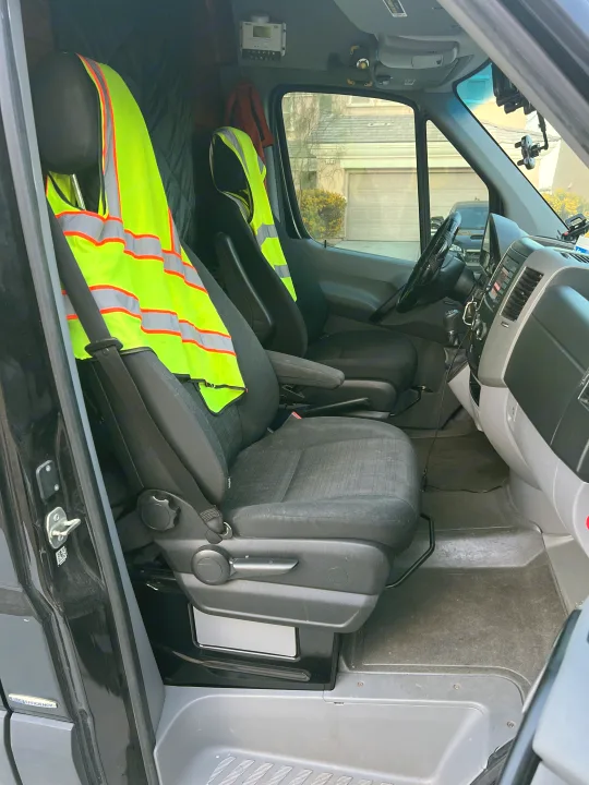 RV rental van's interior: driver & passenger seats with safety vests, dashboard, and floor. Ready for the road.. Mercedes-Benz Sprinter 2016