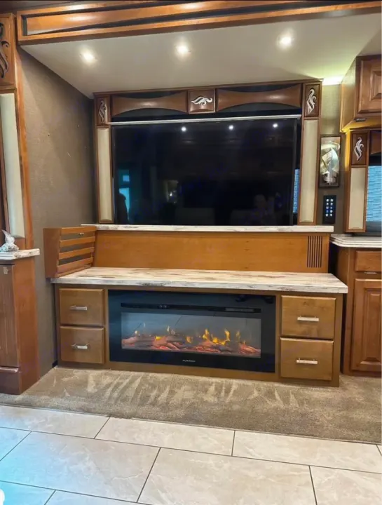 RV rental: Spacious interior featuring a large TV, electric fireplace, and elegant wood cabinetry. Perfect for cozy relaxation.. Tiffin Motorhomes Phaeton 2019