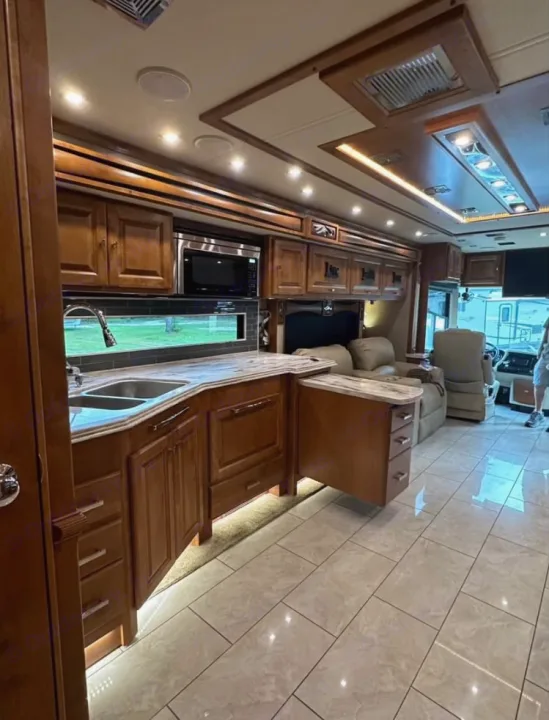 Luxurious rv rental kitchen and living area. Polished tile floors, warm wood cabinetry, and ambient lighting for comfortable travel.. Tiffin Motorhomes Phaeton 2019