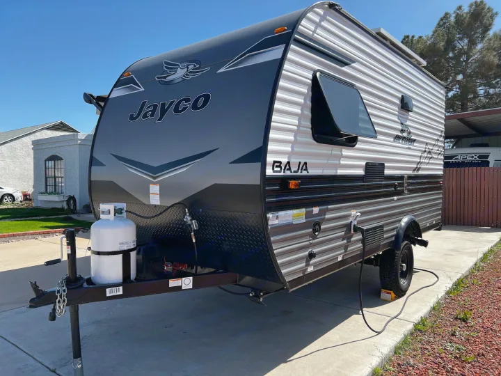 Experience travel freedom! This modern Jayco Baja travel trailer, equipped and parked on concrete, is perfect for your rv rental needs.. Jayco Jay Flight SLX Baja Edition 2023