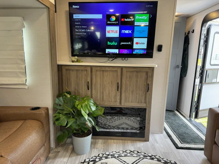 Modern RV rental interior with Roku smart TV, streaming apps, comfy seating, and electric fireplace for home-like comfort.. Forest River Vibe 34BH 2024