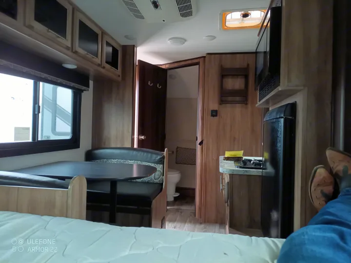 RV rental interior: dining area, kitchen, bed, and bathroom access. Ideal for comfortable road trips.. Jayco Hummingbird 2018