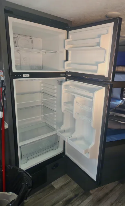 See inside this clean, empty two-door refrigerator in your RV rental, ready for food storage.. Forest River ASPEN TRAIL 2024