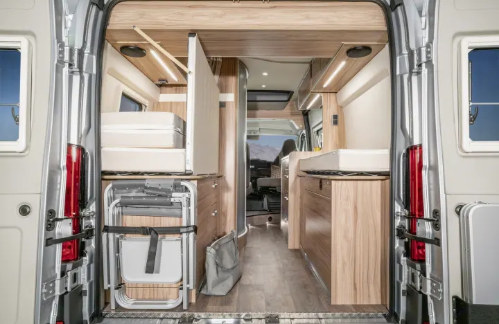 Explore this modern RV rental's versatile interior from the rear, featuring convertible beds, clever storage, and scenic views.. Hymer Ayers Rock 2024