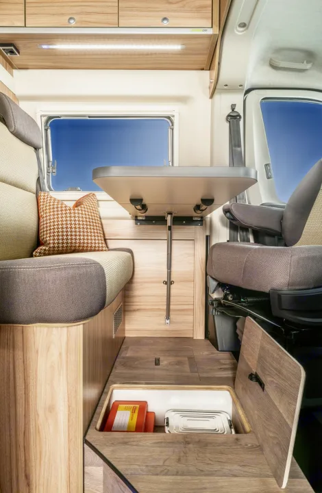 RV rental interior: A compact camper van features a dinette, swivel seat, and hidden floor storage for travel.. Hymer Ayers Rock 2024