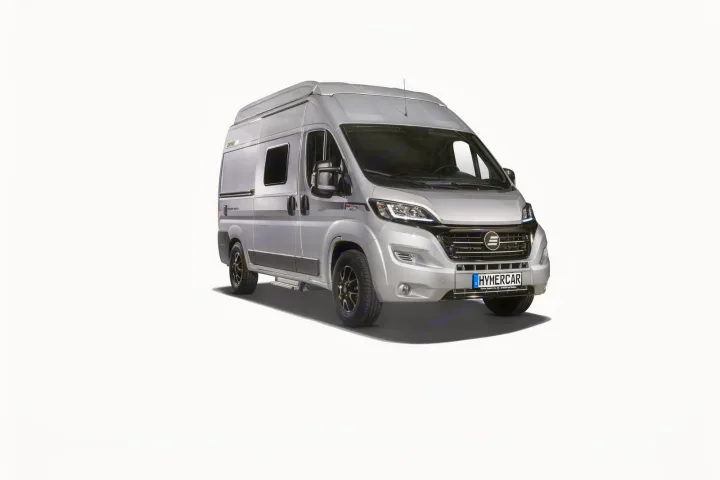 This silver RV rental camper van, seen from the front-right, stands against a clean white background.. Hymer Ayers Rock 2024