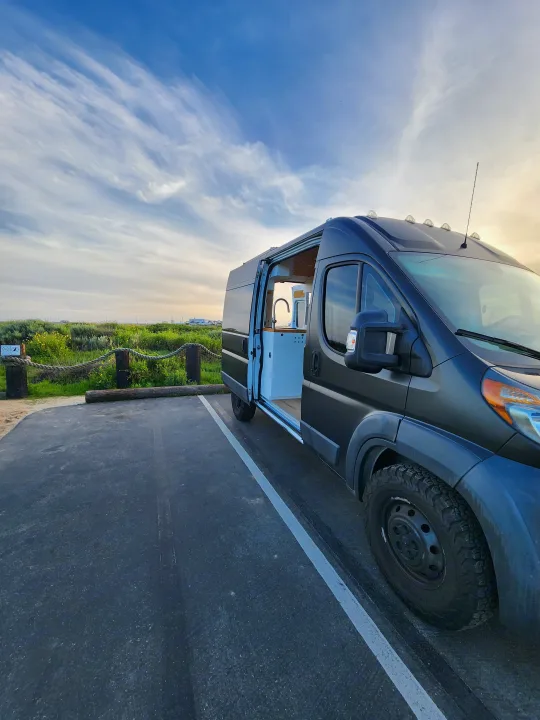 This sleek dark gray camper van rv rental features an open kitchen setup, perfect for your next road trip adventure.. Dodge Sprinter Van 2015