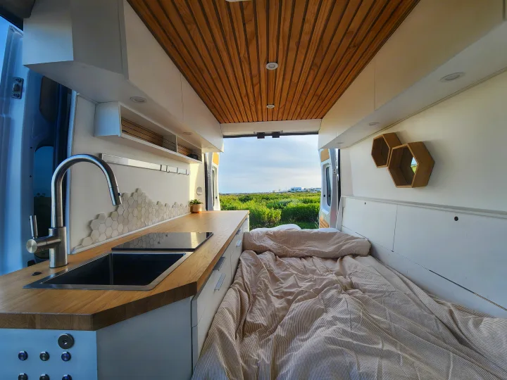 Spacious RV rental interior with modern kitchen, comfy bed, and open views. Perfect for adventure travel.. Dodge Sprinter Van 2015