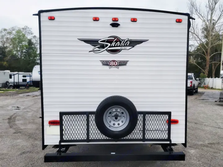Explore the outdoors with this Shasta travel trailer RV rental, featuring a rear spare tire and cargo rack.. Forest River Shasta 2022