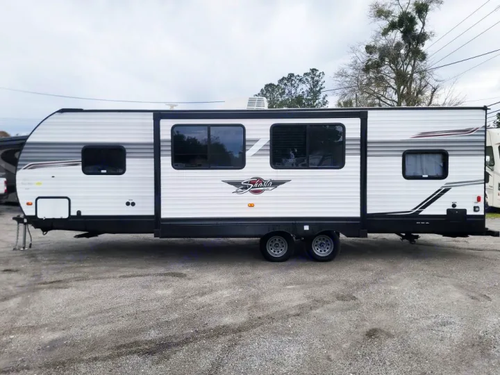 White Shasta travel trailer, ideal for an rv rental, features a spacious slide-out, perfect for your next camping trip.. Forest River Shasta 2022