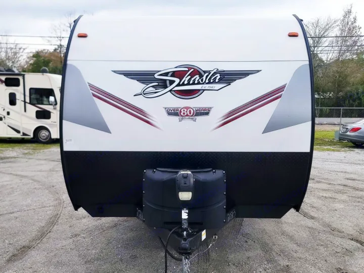 White Shasta travel trailer, a great option for RV rental. Shows front with black diamond plate & propane tank cover.. Forest River Shasta 2022