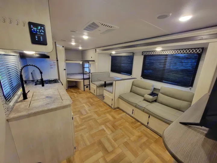 Spacious RV rental interior featuring kitchen, bunk beds, dinette, and cozy sofa living space.. Forest River Shasta 2022